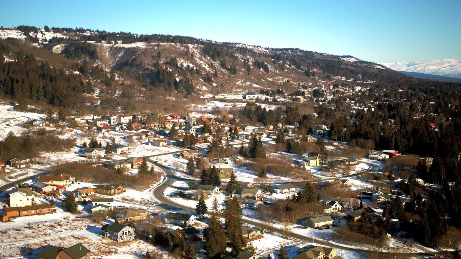  A panoramic view of a snowy mountain range under a clear blue sky, showcasing peaks covered in fresh snow.